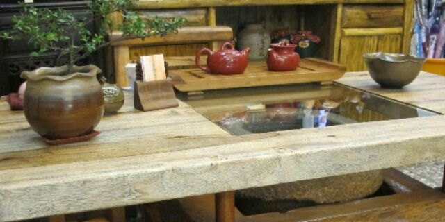 藝峰行店內的原木茶桌,桌上放著陶製茶壺與茶盤